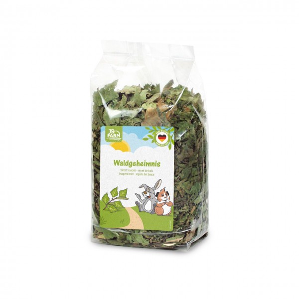 Transparenter Beutel mit getrockneten grünen Blättern, aufrecht stehend. Etikett mit "JR FARM" und "Waldgeheimnis" sowie Illustration von Hase und Meerschweinchen auf einem Waldweg. Herz mit deutscher Flagge und "MADE WITH LOVE".