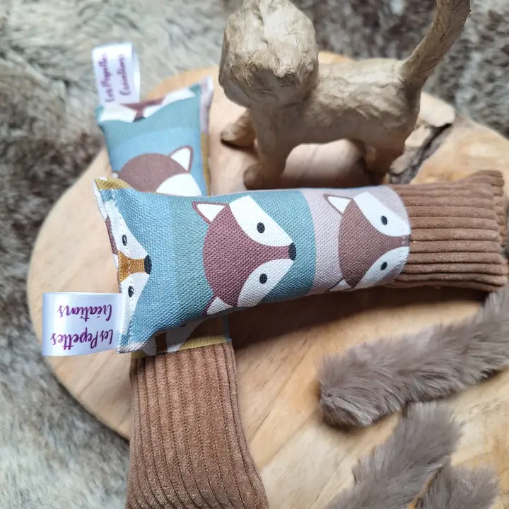 Auf einer Holzscheibe liegen zwei Kissen mit Fuchsmotiv, eine Figur und etwas Fell.