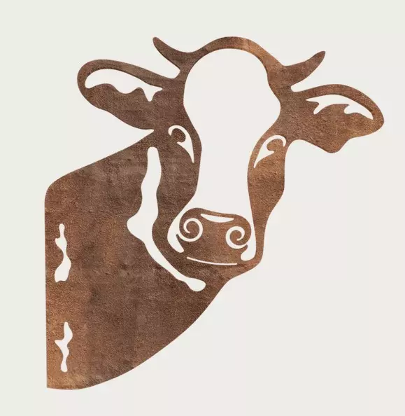 Rust-coloured cow animal silhouette with cut-outs for details such as eyes and nostrils on a light background.