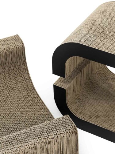 Due elementi curvi in cartone ondulato marrone sovrapposti su sfondo chiaro. Si vede la trama fine degli strati. I bordi esterni lisci contornati di nero indicano un design moderno per tiragraffi o cucce per gatti.