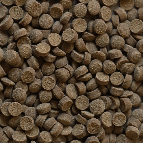 Nahaufnahme von DuplaRin Crusta Snack, braunes Granulat für Krebse und Krabben, texturierte Oberfläche.