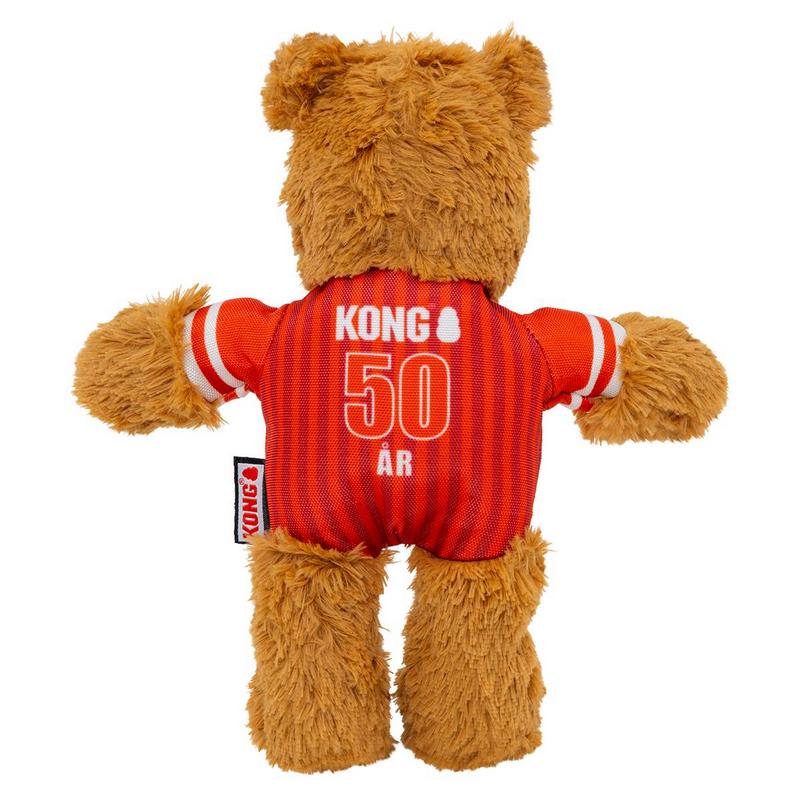 Orsacchiotto di peluche marrone visto da dietro. Indossa una maglietta a righe rosse con polsini bianchi. Sulla schiena la scritta "Kong", il numero grande "50" e la parola "ÅR". Arti morbidi, etichetta nera Kong sul lato.