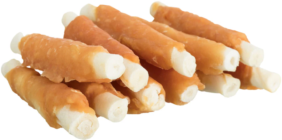 Una pila di snack cilindrici per cani giace su uno sfondo chiaro. Ogni snack ha un cuore chiaro e compatto, avvolto da uno strato di carne secca dorata e leggermente irregolare. Le estremità chiare sporgono su entrambi i lati.