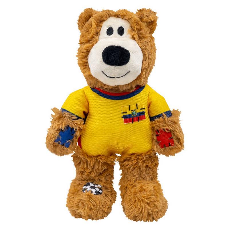 Orsacchiotto di peluche marrone, in posizione eretta. Maglietta gialla con colletto rosso-blu e stemma giallo-blu-rosso. Tachine rosse/blu sulle maniche, pallone da calcio sul piede sinistro. Bocca bianca, naso nero, sorriso.