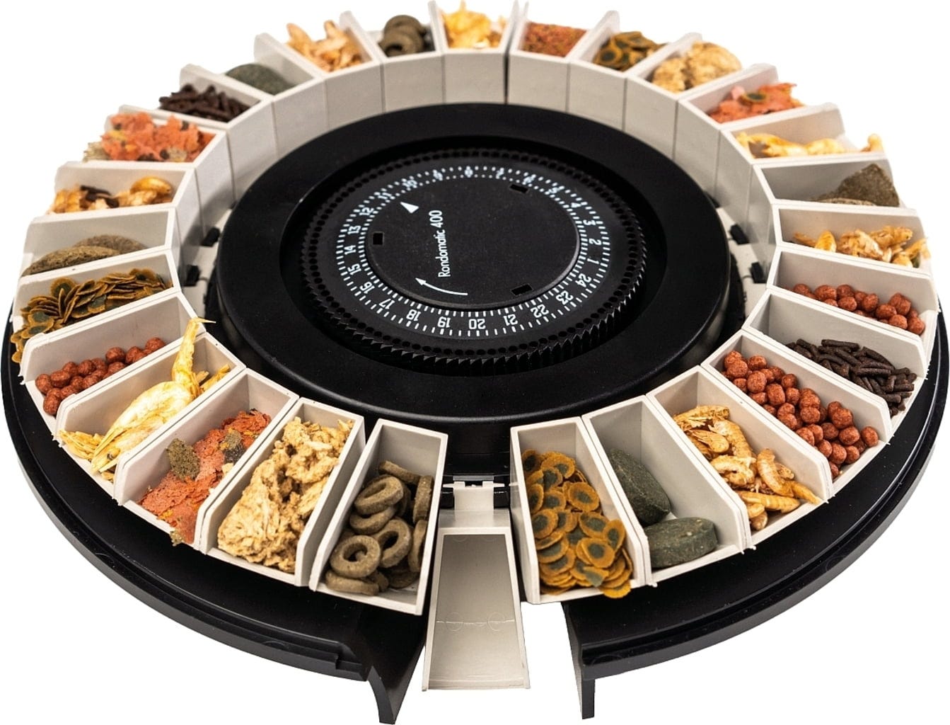 Distributeur automatique de nourriture pour poissons Rondomatic 400, avec compartiments blancs en cercle, remplis de nourriture sèche (flocons, granulés, pastilles) de couleurs et textures variées. Au centre, cadran noir pour régler l'heure.