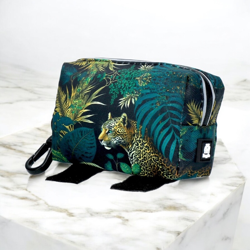Cosmetic bag with jungle and leopard pattern on marble top, zip at the top, black snap hook.