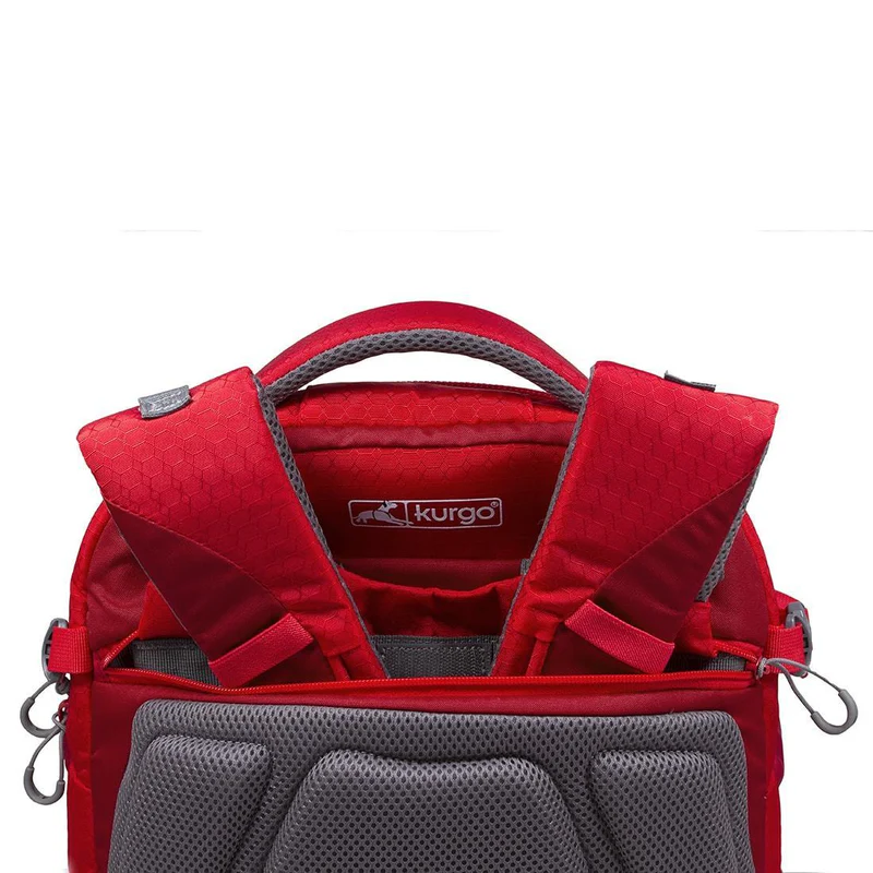 Detailed view of a red Kurgo backpack with padded straps and breathable back section. The logo is visible.
