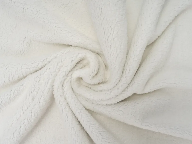 Primo piano: morbido vello Sherpa bianco con struttura a spirale. Coperta per cani Pearl.