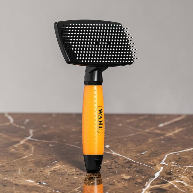 Wahl ’s orange and black slicker brush on a brown marble base, with a black brush head and plenty of white, rounded bristles. Orange handle featuring the ‘ Wahl ’ logo.