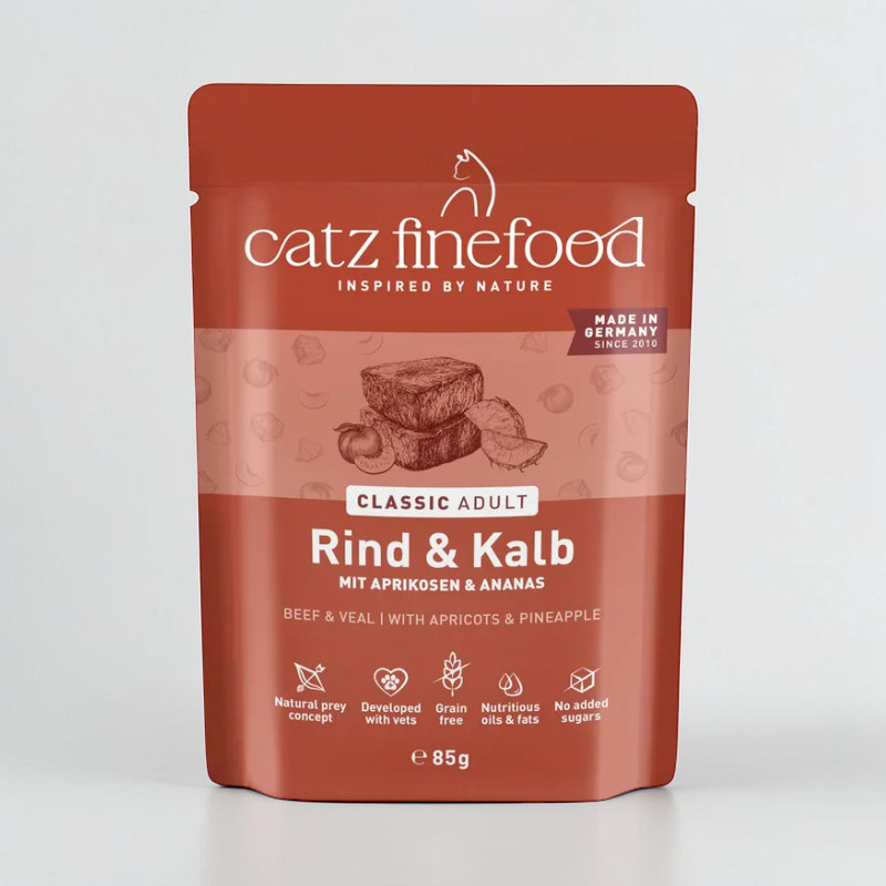 Roter Beutel Catz finefood Classic Adult Katzenfutter Rind & Kalb mit Aprikosen & Ananas. Logo 'catz finefood' und 'Made in Germany'. Bilder von Rindfleisch, Aprikose, Ananas. Hinweise: 'Getreidefrei', 'Ohne Zuckerzusatz', 'e 85g'.
