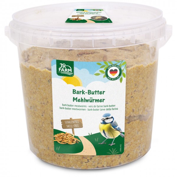 Large transparent bucket of JR Farm Bark-Butter mealworms bird feed. On the label: a blue tit and a pile of shell-free mealworms on a path under a sunny sky. Feed: granular, light brown.