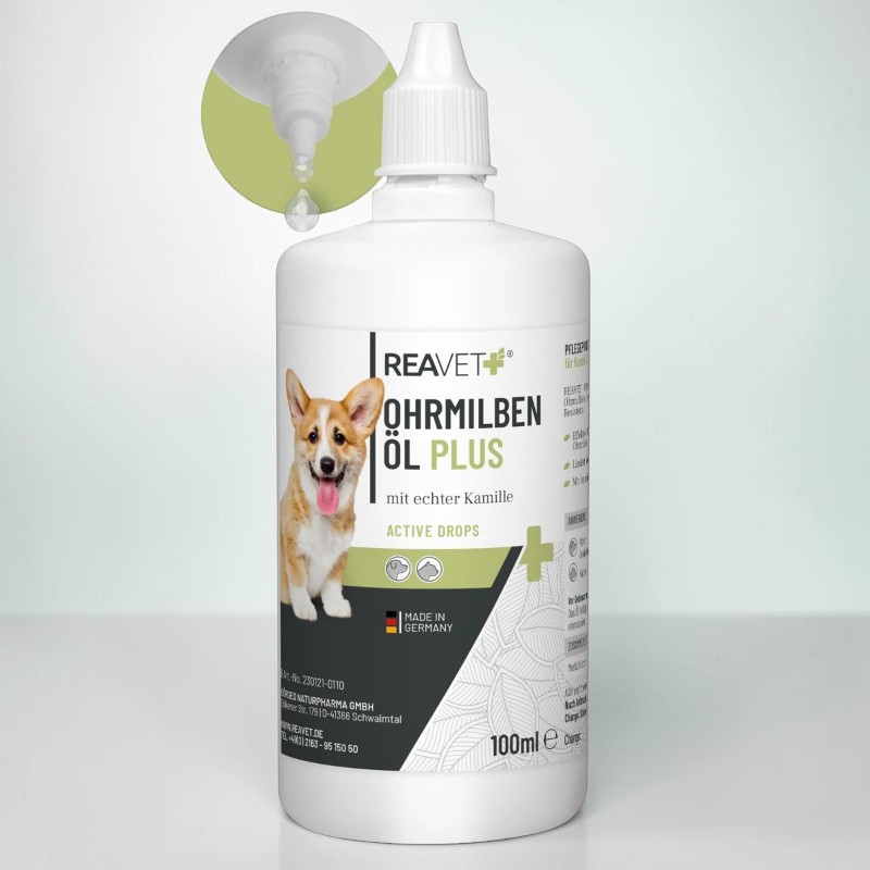 Weiße Flasche REAVET Ohrmilben Öl Plus mit lächelndem Corgi auf dem Etikett, daneben „mit echter Kamille“. Oben links ein vergrößerter Tropfenspender mit klarem Tropfen. „Made in Germany“, 100 ml.