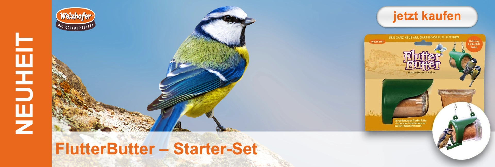 Farbenfrohe Blaumeise mit blauem Kopf, weißen Wangen und gelber Brust sitzt auf einem Felsen vor blauem Himmel. Rechts das Produkt "FlutterButter Starter-Set" in der Verpackung. Links steht "NEUHEIT".
