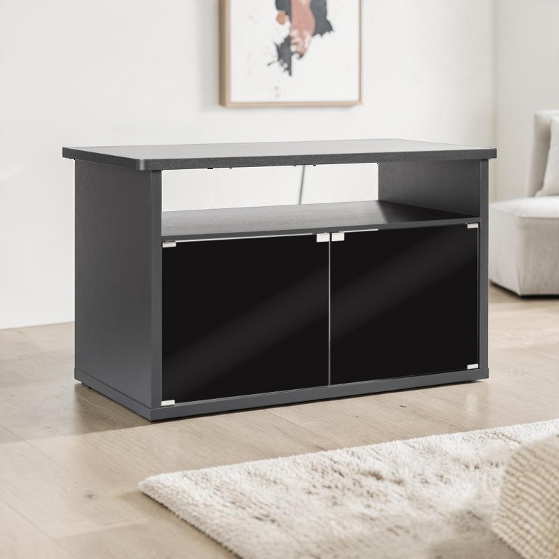 Meuble de rangement Exo Terra Vista 120 noir, robuste, avec tablette supérieure, compartiment ouvert et deux portes fermées offrant du rangement, idéal comme base pour terrarium. Posé sur parquet clair avec tapis, devant mur blanc.