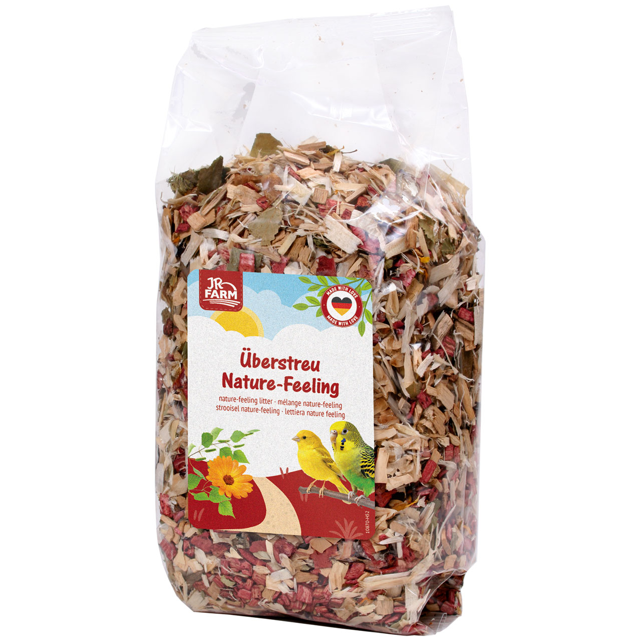 Sachet transparent de litière « JR Farm » « Nature-Feeling », mélange de copeaux de bois clairs, de feuilles vertes et de plantes rouges. Étiquette avec deux petits oiseaux sur une branche, une fleur orange et le nom du produit.