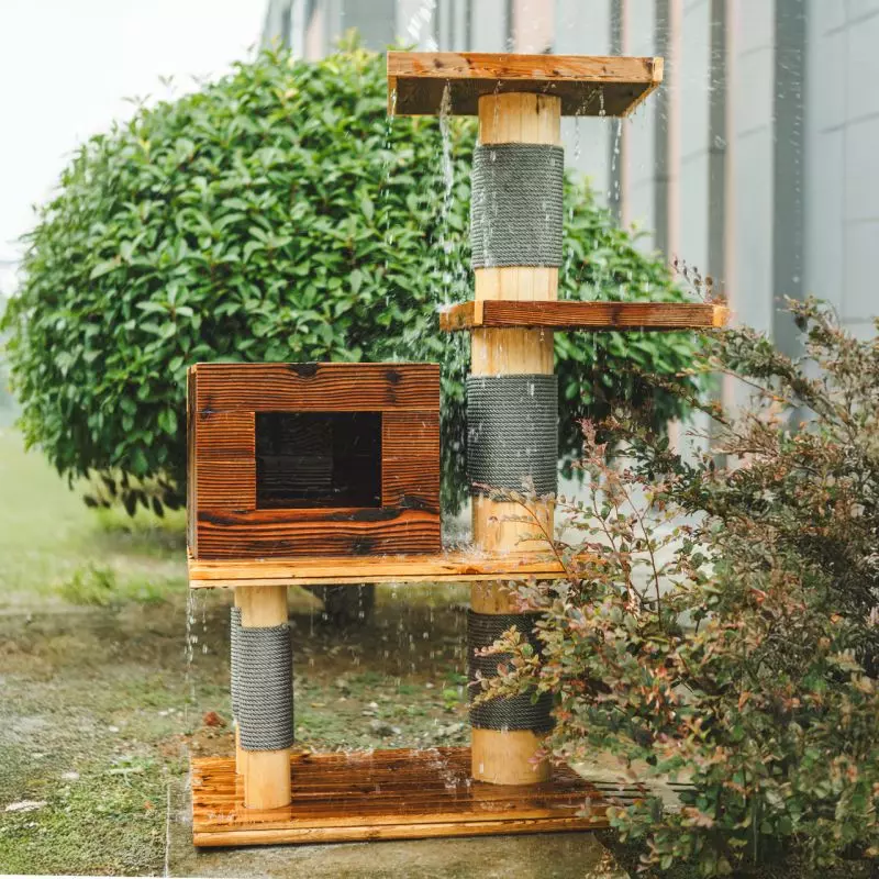 Arbre à chat d'extérieur Woody en bois avec niche pour chats et colonnes à griffer sous la pluie. Plateformes pour grimper et se reposer pour les chats.