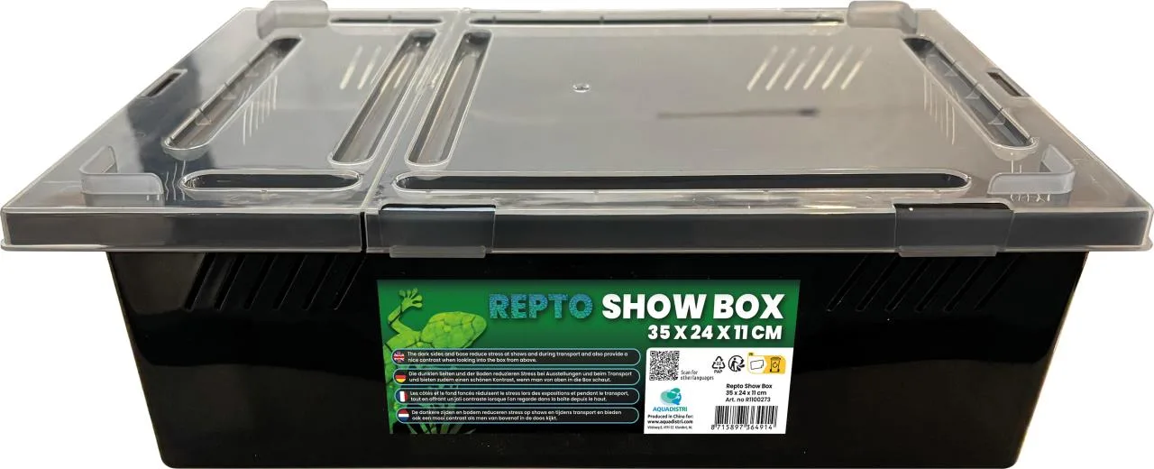 Schwarze, rechteckige Kunststoff-Transportbox mit transparentem Deckel, Belüftungsschlitzen und mittiger Trennwand. Vorn grünes Etikett „REPTO SHOW BOX“ mit Eidechse, Maße 35x24x11 cm. Dunkle Seiten reduzieren Stress.
