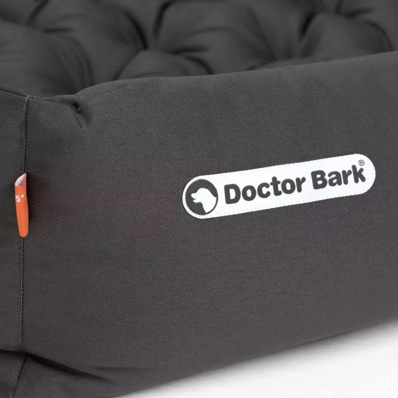 Detailaufnahme: Graues orthopädisches Hundebett von Doctor Bark, Logo sichtbar, mit gesteppter Liegefläche und hohem Rand.