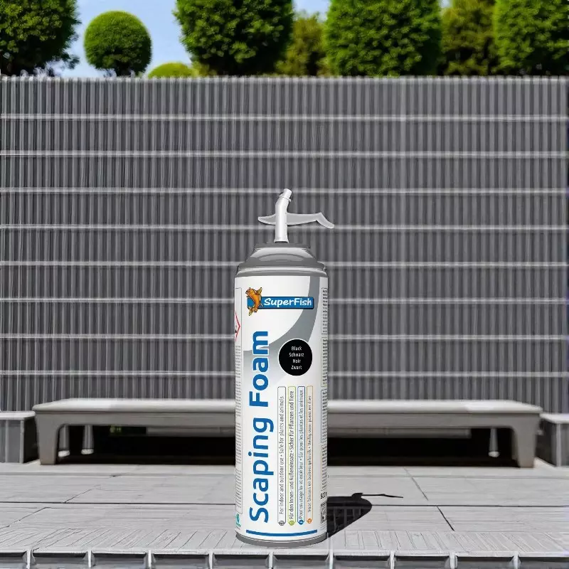 Silver construction foam can "SuperFish Scaping Foam" in front of grey fence and plants. Printed with logo, text and safety information.