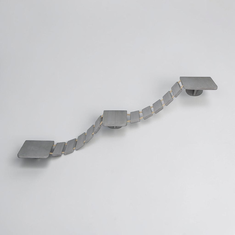 Échelle d'escalade taupe pour chats sur mur gris clair. Trois plateformes rectangulaires reliées par une passerelle souple de petites marches en bois et cordes en sisal, montant en serpentant, pour grimper et se reposer en hauteur.