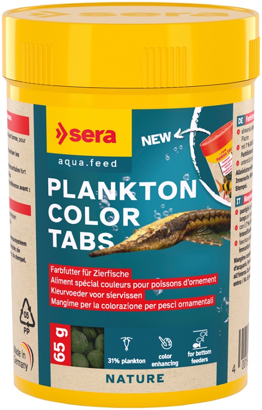 Yellow cylindrical container for ‘ Sera ’ Plankton Colour Tabs. Dark blue label featuring a brown catfish in water. Small illustration showing green, round food tablets. Coloured food for ornamental fish, 31% plankton, 65 g.
