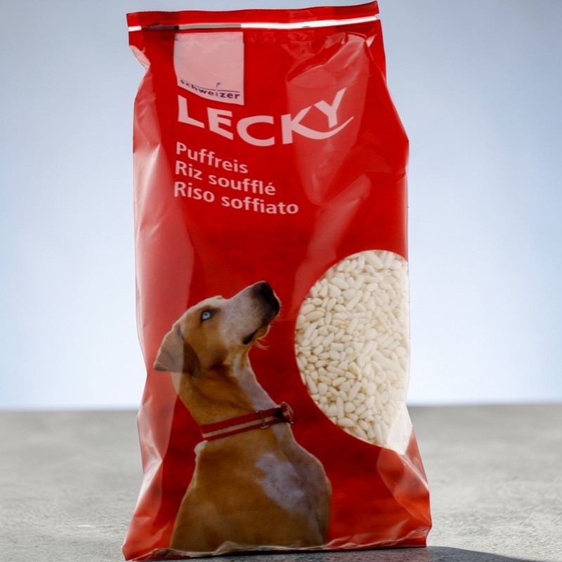 Sacchetto rosso di cibo per cani "Lecky". Mostra un cane con un collare rosso e una manciata di riso soffiato.