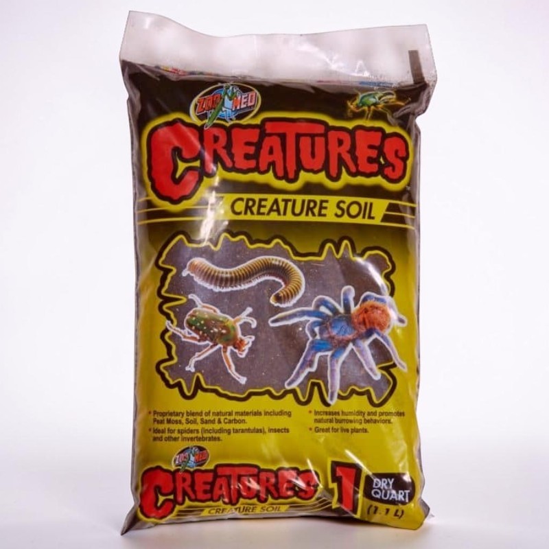 Braune Verpackung "Zoo Med Creatures Creature Soil" mit Tausendfüßler, Käfer, blauer Spinne. Text nennt Inhaltsstoffe: Torfmoos, Erde, Sand, Kohlenstoff; ideal für Spinnen/Insekten. Inhalt: 1,1 Liter.