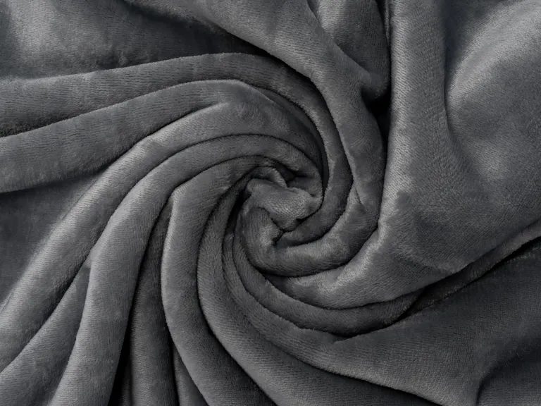 Primo piano di una morbida coperta grigia per cani disposta a spirale.