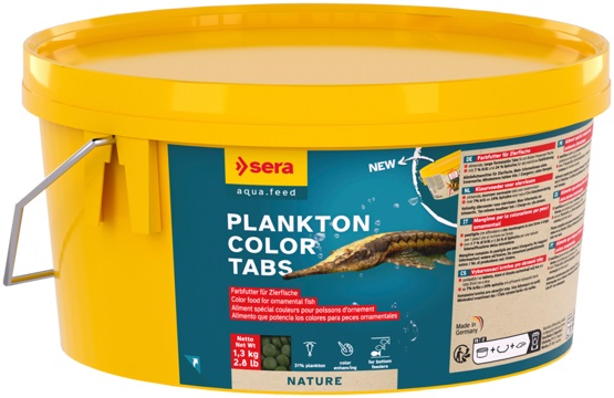 Yellow bucket containing ‘ Sera ’ Plankton Colour Tabs, colour-enhancing food for ornamental fish. Blue label featuring a brown, elongated bottom-dwelling fish and small green pellets. Text reads: ‘colour enhancing’, ‘for bottom feeders’, 1.3 kg.