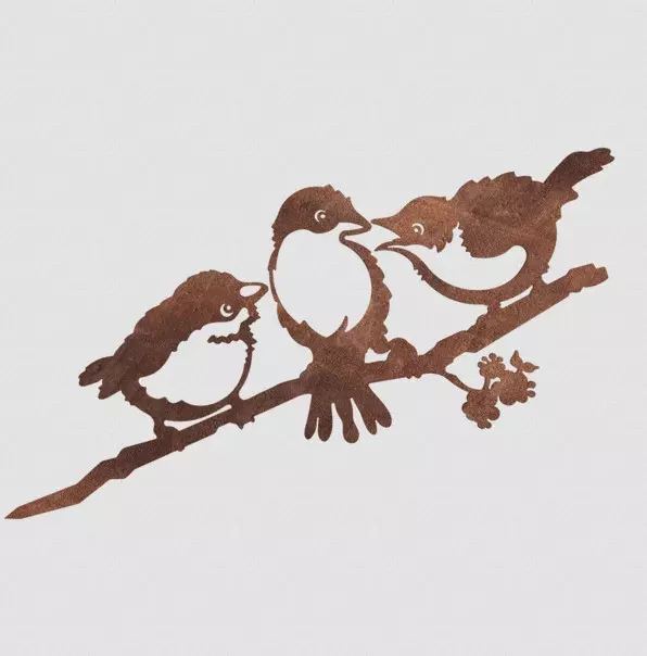 Three metal chicks sitting on a branch, a tree ornament for the garden. Rust-coloured silhouette.