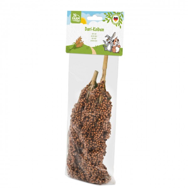 Transparent bag with two dried Dari cobs, densely covered in reddish-brown grains, on a white background. Product label at top with JR Farm logo, ‘Dari cobs’ name and landscape illustration. Pet food for rodents.