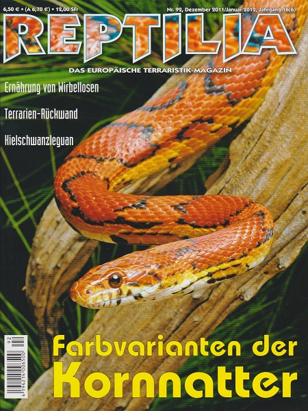 Un serpent des blés jaune-orange vif, parsemé de taches rouge foncé, s'enroule autour d'une branche. Ses écailles ont un motif typique de cette variante. Il regarde vers l'avant, sur fond flou de feuilles vertes.