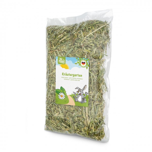 Transparent plastic bag containing dry, green hay/herbs. On the front is a white label featuring ‘JR Farm’ and ‘Herb Garden’, a cartoon rabbit next to daisies on a path, and a small German flag symbol.